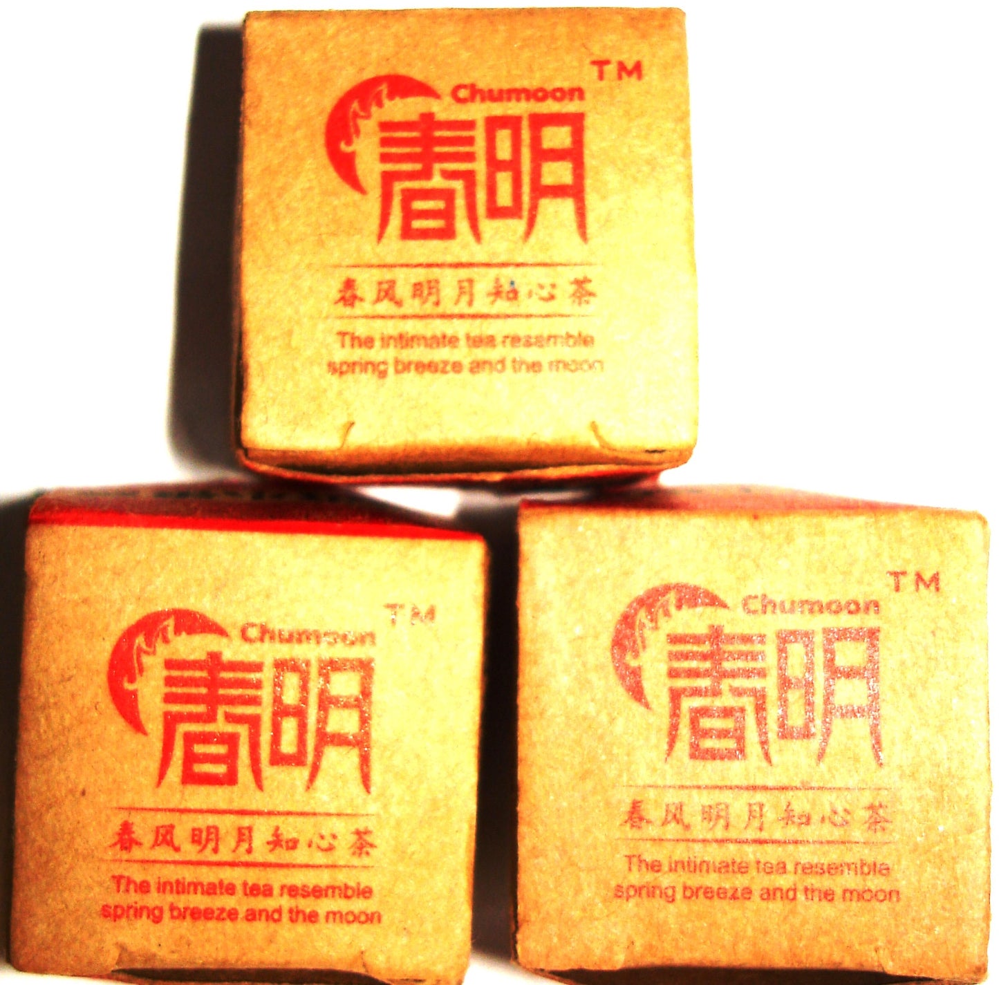 Three bricks of Chun Moon Sheng Pu-ehr tea in gold packaging with red lettering