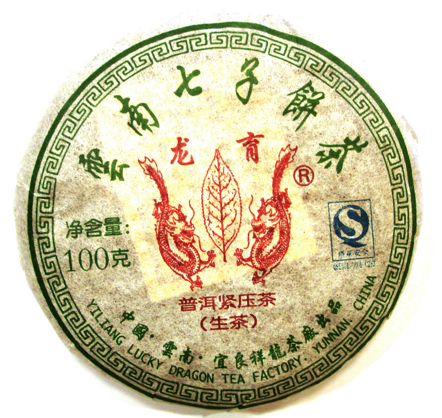 Lucky Dragon Chinese Sheng pu-erh tea cake in white packaging with green characters and red design
